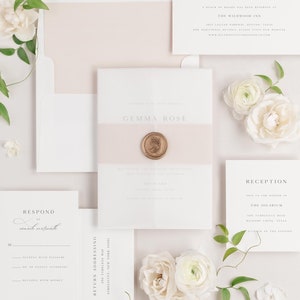 Gemma invitation flat lay with rose gold envelope liner, rose gold belly band, translucent vellum jacket, and gold wax seal.