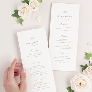 May include: Two white cards with a light blue floral design and the text "Bon Appetit" at the top. The cards list a wedding menu with the headings "Canopie", "Entree", and "Dessert".