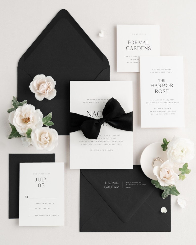Black and white wedding invitation suite with rsvp card and enclosures along with a black envelope with white printing.