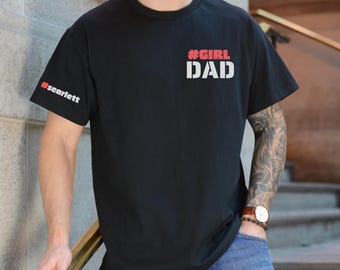 May include: Black t-shirt with the text "#GIRL DAD" in white and red. The sleeve has the text "#scarlett" in red. The shirt is made of a soft material.