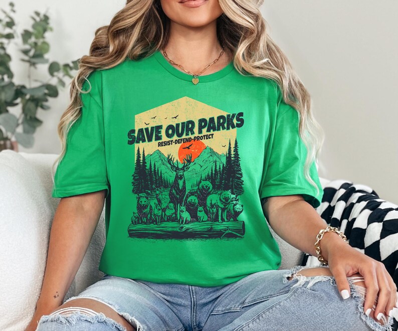 May include: Green t-shirt with a graphic of a forest scene and the text "Save Our Parks Resist-Defend-Protect".