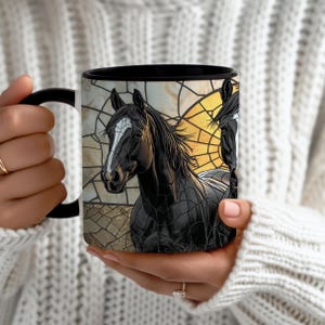 May include: Black coffee mug featuring a detailed illustration of a black horse with a white blaze, set against a stained-glass style background. The mug has a black handle and rim, and the design showcases equine art.