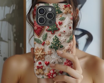 May include: A phone case featuring a festive Christmas cookie design. The case displays gingerbread men, Christmas trees, snowflakes, and hearts in red, green, and white. The case has a textured appearance, giving the impression of baked goods.