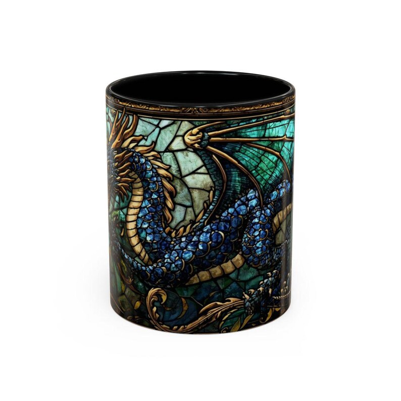 May include: A cylindrical ceramic mug featuring a vibrant stained glass design of a blue and gold dragon. The dragon is depicted with intricate scales and wings against a teal and turquoise geometric background with dark gold filigree accents.