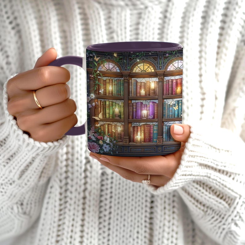 Peut inclure: Un mug en c&eacute;ramique pr&eacute;sentant une illustration d&eacute;taill&eacute;e d'une biblioth&egrave;que en bois &agrave; plusieurs niveaux remplie de livres color&eacute;s, de bougies allum&eacute;es et de fleurs. Le motif inclut des arches architecturales et de petits papillons.