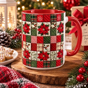May include: A ceramic mug with a red interior and handle, featuring a quilted-style pattern of red poinsettias, green plaid, and white fabric squares. The mug has a glossy finish and a cylindrical shape, displaying a festive holiday-themed design.