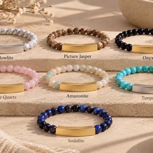 May include: Seven beaded bracelets with metal bars. The bracelets feature Howlite, Picture Jasper, Onyx, Rose Quartz, Amazonite, Turquoise, and Sodalite beads. Each bracelet has a smooth, curved metal bar in either a gold or silver tone.