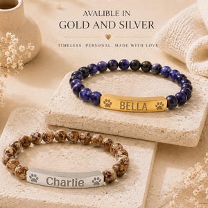 May include: Two beaded bracelets featuring a central metal bar. The top bracelet has dark blue beads and a gold-toned bar engraved with 'BELLA' and paw prints. The bottom bracelet has brown speckled beads and a silver-toned bar engraved with 'Charlie' and paw prints.