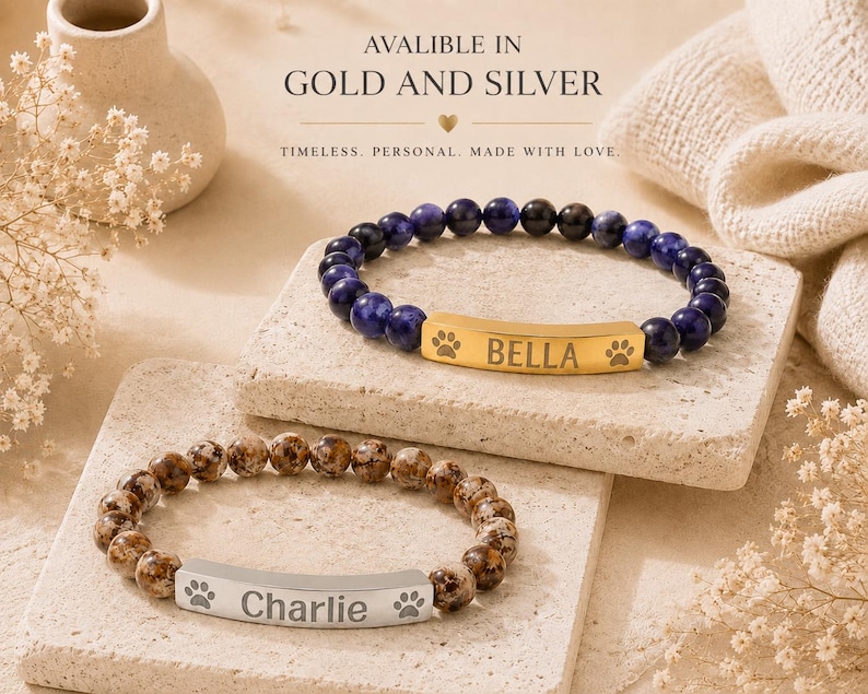 May include: Two beaded bracelets featuring a central metal bar. The top bracelet has dark blue beads and a gold-toned bar engraved with 'BELLA' and paw prints. The bottom bracelet has brown speckled beads and a silver-toned bar engraved with 'Charlie' and paw prints.