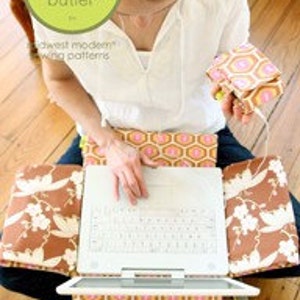 May include: A brown and white patterned laptop cover with a matching smaller case. The laptop cover has a floral design with white flowers and vines on a brown background. The smaller case has a geometric pattern with pink and yellow hexagons on a brown background. The text "laptop cover & mp3 case" is printed below the image.