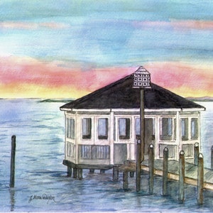 May include: A watercolor painting of a white gazebo on a wooden dock over the water. The gazebo has a black roof and a birdhouse on top. The water is a light blue color and the sky is a light blue with pink and orange clouds. The painting is signed "J. Marie Dickson".
