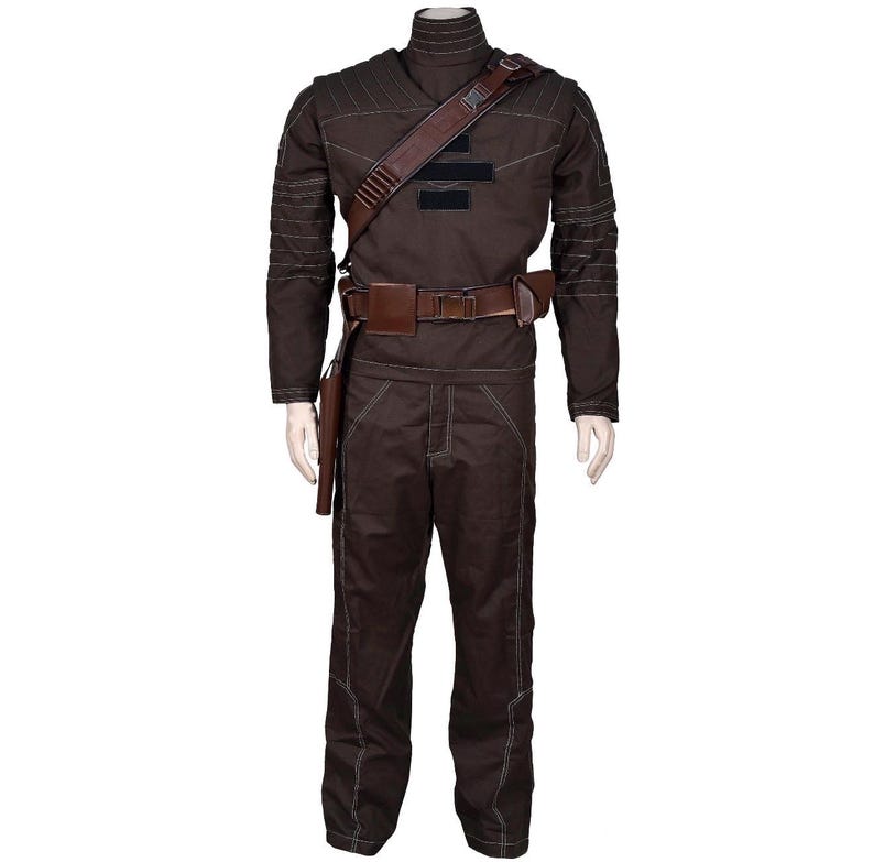 May include: A brown costume with a high collar, long sleeves, and matching pants. The outfit includes a brown leather belt, shoulder strap, and holster. White stitching accents the seams of the costume. The costume is displayed on a mannequin.