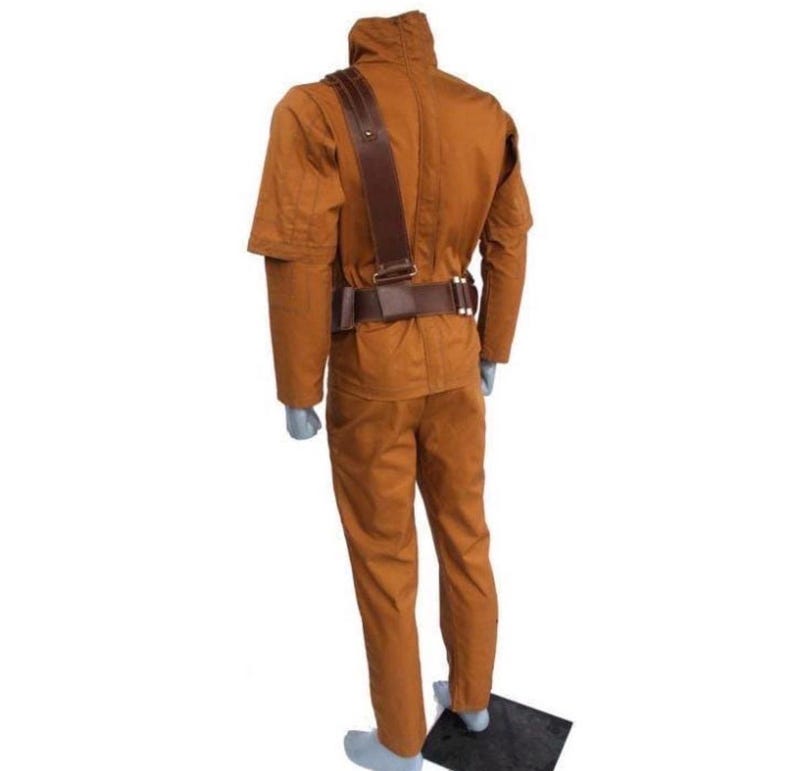 Może przedstawiać: Brązowy kostium składający się z kurtki, spodni i paska. Kurtka ma wysoki kołnierz i pasek na ramię. Pasek ma klamrę i kilka małych kieszeni. Spodnie mają proste nogawki. Kostium jest wykonany z wytrzymałej tkaniny.