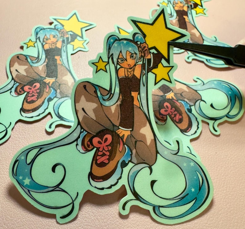 May include: A die-cut sticker featuring an anime-style character with long flowing teal hair, wearing a dark brown crop top and tan pants with star patterns. The character is crouching and holding a bright yellow star, surrounded by smaller yellow stars.