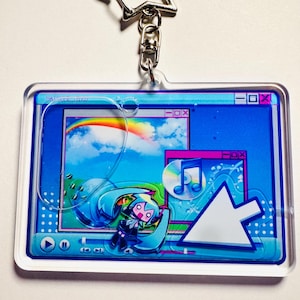 May include: A rectangular acrylic keyring featuring a star-shaped metal clasp. The design displays a retro computer interface with a blue background, a rainbow, a music note icon, and a stylised anime character with teal hair and a large cursor.