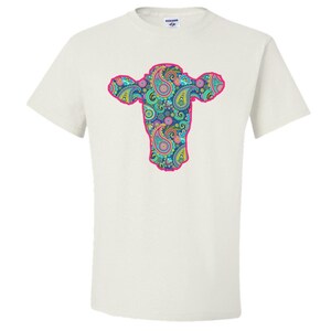 May include: White t-shirt featuring a pink outline of a cow's head filled with a paisley pattern in shades of blue, green, pink, and yellow.