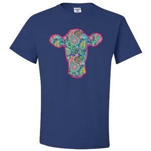 May include: A navy blue t-shirt featuring a pink outline of a cow's head filled with a paisley pattern in shades of blue, green, pink, and yellow.