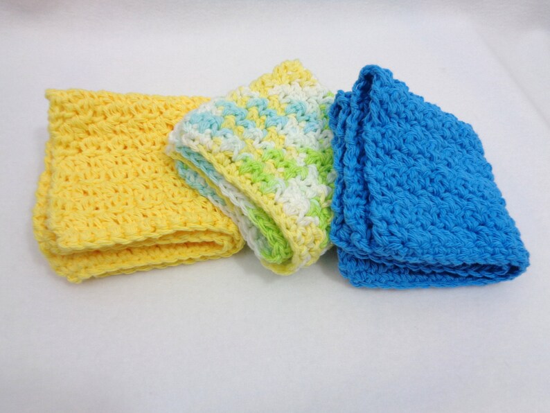 May include: Three crocheted dishcloths in yellow, green and white, and blue.