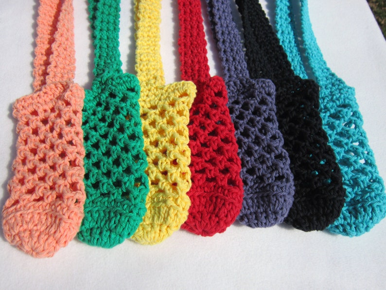 May include: Eight crocheted bags in various colors, including peach, green, yellow, red, gray, black, and turquoise. The bags are made with a simple mesh pattern and have a loop at the top for hanging.