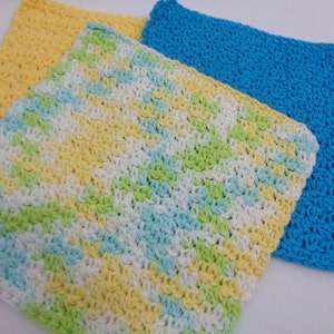 May include: Three crocheted dishcloths in yellow, blue, and a multi-colored pattern of yellow, green, white, and blue.
