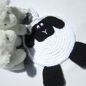 以下が含まれることがあります： 白地に黒の顔と脚を持つ、手編みの羊。手作りのアイテムで、どんな家のインテリアにも最適です。