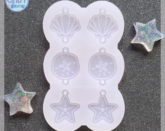 May include: A white silicone mold with six different shapes: two seashells, two sand dollars, and two starfish. The mold is designed for making resin earrings or other small crafts.