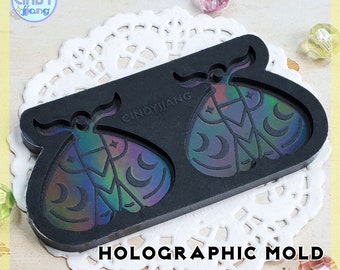 May include: Black silicone mold with two holographic moth shapes. The mold is labeled "CINDYJIANG" and "HOLOGRAPHIC MOLD".