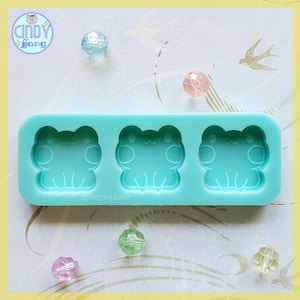 May include: A light blue silicone mould with three frog-shaped cavities. The mould is designed for making resin crafts.