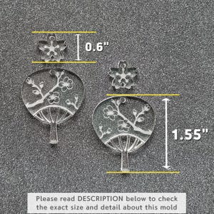 May include: Two clear acrylic molds for crafting. The larger mold is 1.55 inches tall and 0.6 inches wide and features a Japanese fan design with cherry blossoms. The smaller mold is 0.6 inches wide and features a single cherry blossom.