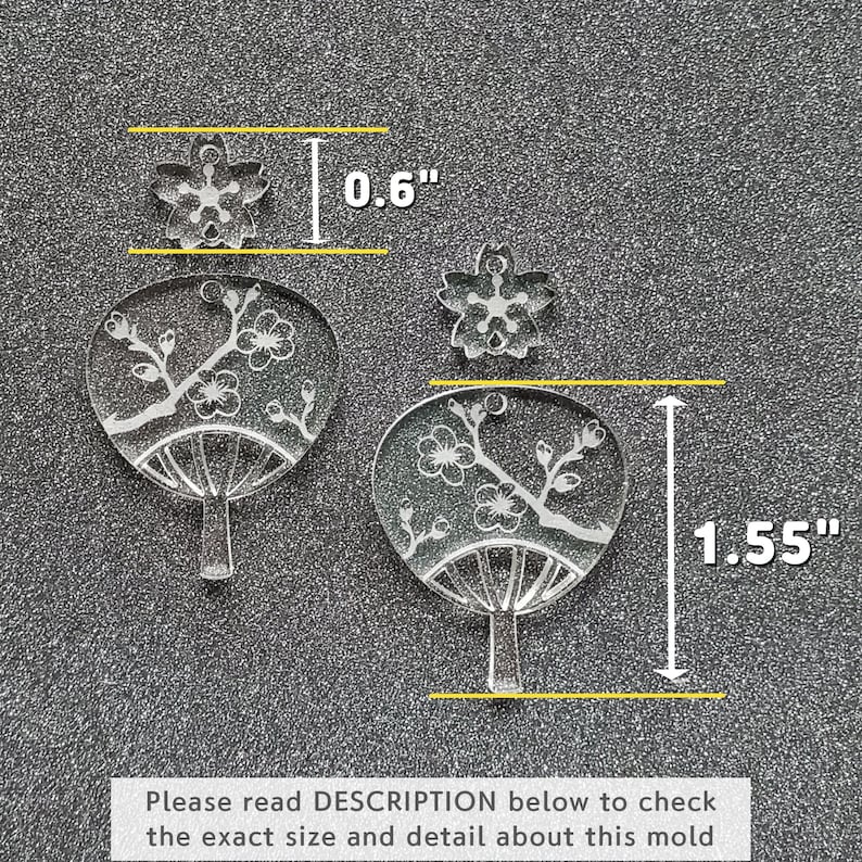 May include: Two clear acrylic molds for crafting. The larger mold is 1.55 inches tall and 0.6 inches wide and features a Japanese fan design with cherry blossoms. The smaller mold is 0.6 inches wide and features a single cherry blossom.