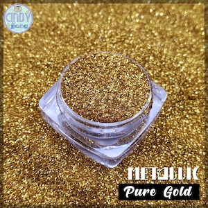 May include: A clear, square container filled with metallic pure gold glitter. The container sits on a bed of gold glitter. The text "METALLIC Pure Gold" is displayed in a black rectangle at the bottom of the image. The Cindy Fang logo is in the top left corner.