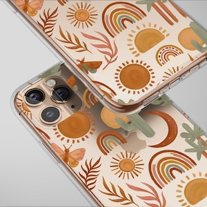 Może przedstawiać: Dwa przezroczyste etui na telefon z powtarzającym się wzorem słońc, tęczy, motyli i liści w odcieniach pomarańczu, brązu i zieleni. Etui mają złoty obramowanie i są umieszczone na jasnoszarym tle.