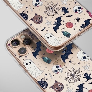 May include: Two clear phone cases with a repeating Halloween-themed pattern. The design includes ghosts, bats, skulls, spiders, and potion bottles in black, white, and brown on a beige background. The cases have a gold-colored frame.