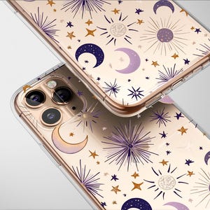 Puede incluir: Una funda transparente para teléfono con un borde dorado y un patrón de estrellas, lunas y soles en tonos de morado, dorado y blanco.