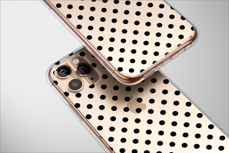 May include: Two clear phone cases with a gold-colored frame and a black polka dot pattern. The cases are angled, showing the camera lenses and the Apple logo. The cases are on a white background.