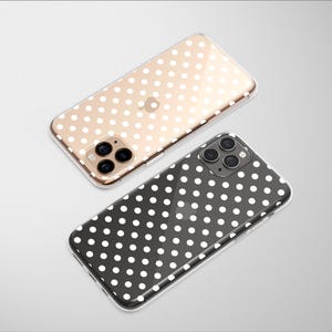 May include: Two clear phone cases with white polka dot patterns. One case is gold and the other is black.