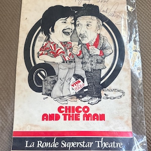 May include: A vintage promotional poster for Chico and the Man at La Ronde Superstar Theatre, featuring a black and white caricature of two characters, one wearing a patterned shirt and the other a hat, with the text Viva La Raza and a signature.