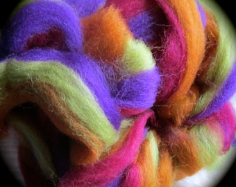 May include: A colourful blend of wool fibres in shades of purple, green, orange, and red. The fibres are arranged in a striped pattern, creating a visually appealing and textured effect.
