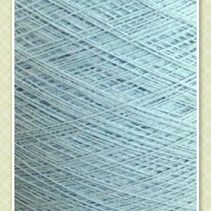 May include: A close-up of a light blue skein of yarn. The yarn is tightly wound and has a smooth texture.
