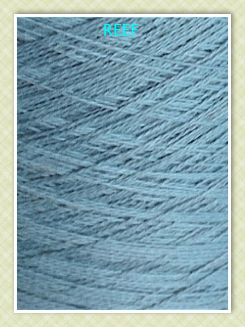 May include: Close-up of a light blue yarn skein with the word "REEF" printed on the label.