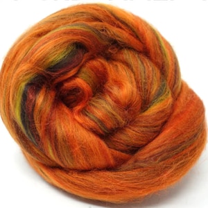 May include: A ball of orange, red, green, and black wool roving. The roving is twisted and piled into a ball shape.
