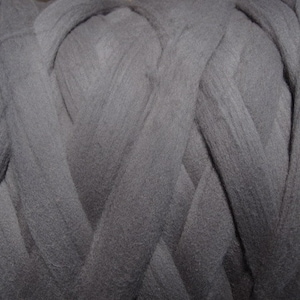 May include: A close-up of a large bundle of dark gray yarn. The yarn is tightly wound and has a soft, fuzzy texture.