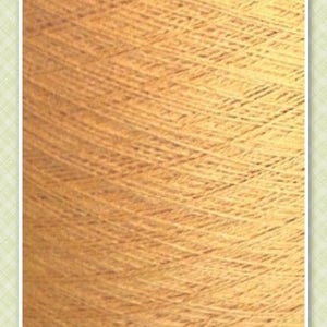 May include: A close-up of a spool of yarn in a warm, golden yellow color. The yarn is textured and has a subtle sheen. The text "SUNFLOWER" is printed on the spool.