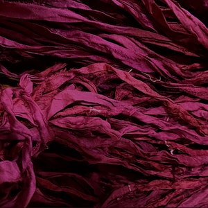 May include: A pile of deep burgundy silk ribbon, perfect for crafting and adding a touch of elegance to projects.
