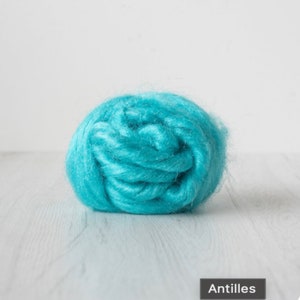 May include: A ball of turquoise blue wool fiber. The fiber is soft and fluffy, and it is perfect for spinning or felting. The fiber is labeled "Antilles".