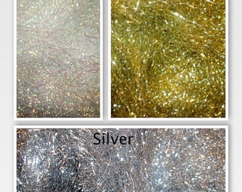 May include: Three panels of metallic fiber material. The top left panel is labeled Aurora Crystalina and shows a shimmering, iridescent white fiber. The top right panel is labeled Gold and shows a metallic gold fiber. The bottom panel is labeled Silver.