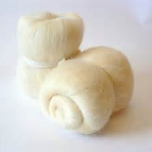 May include: A close-up of several off-white, round, and fluffy bread rolls. One stack of two rolls is tied with a white band. The rolls have a soft, textured appearance, suggesting they are freshly baked.