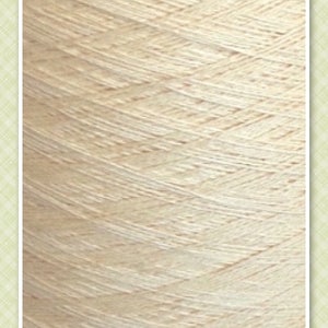 May include: Close-up of a skein of cream-colored yarn. The yarn is made of natural fibers and has a soft, textured appearance. The yarn is labeled "MAGNOLIA".