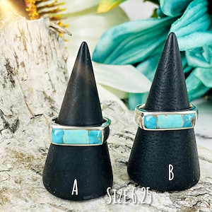Puede incluir: Dos anillos de turquesa y plata en soportes negros. Los anillos est&aacute;n etiquetados como A y B. El texto "SIZE 6.25" est&aacute; debajo de los soportes.