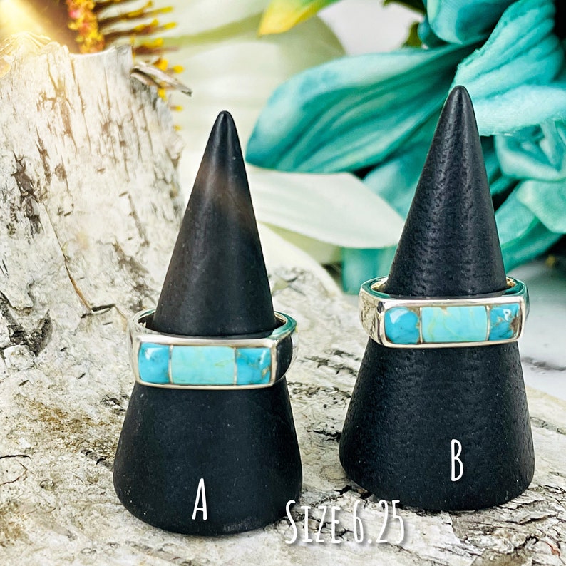 Puede incluir: Dos anillos de turquesa y plata en soportes negros. Los anillos est&aacute;n etiquetados como A y B. El texto "SIZE 6.25" est&aacute; debajo de los soportes.